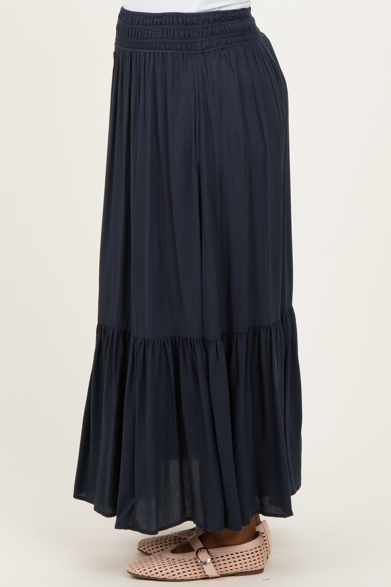 maternity wear navy blue maxi skirt with a tiered design and an elastic waistband, shown in a side view