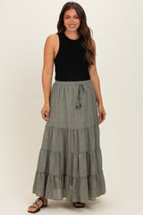 woman wearing a black sleeveless top and a gray tiered maxi maternity skirt with a drawstring waist