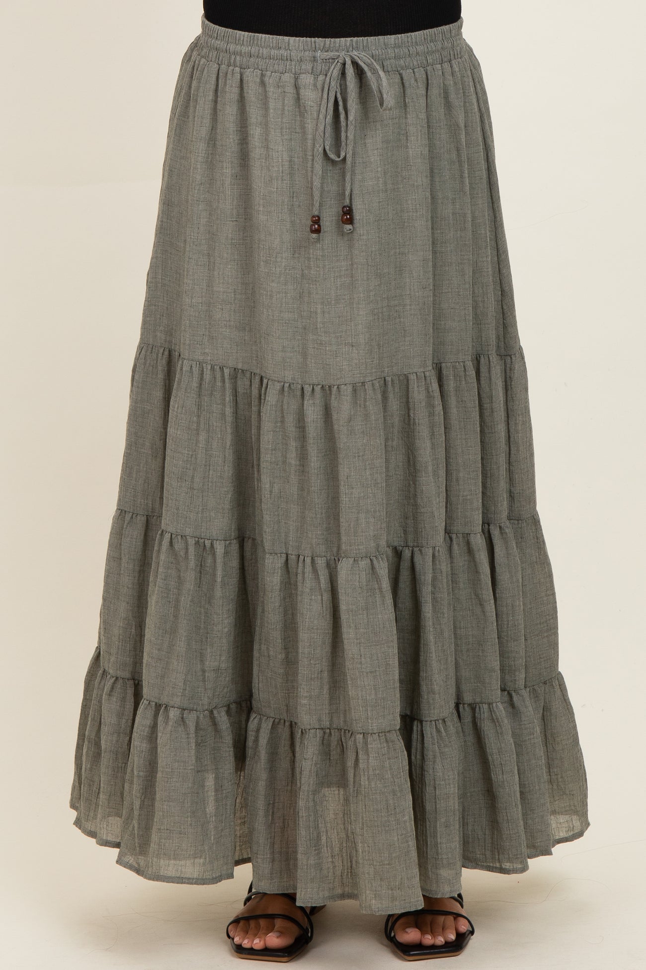 maternity wear tiered gray maxi skirt with an elastic waistband and drawstring detail, model standing and wearing sandals