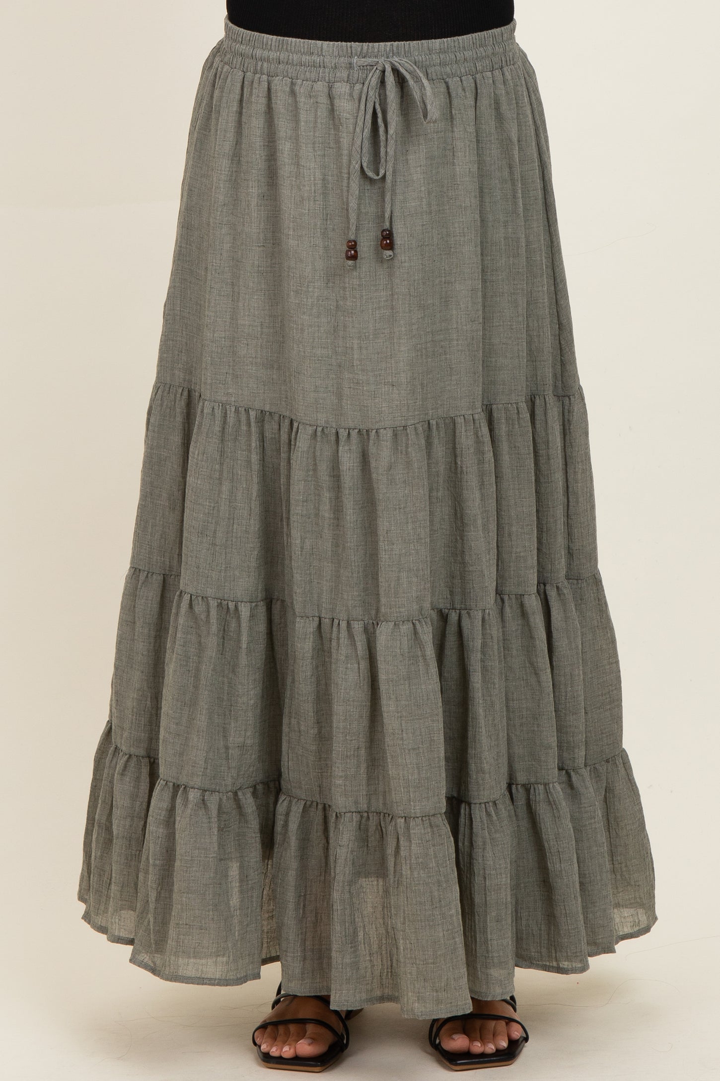 maternity wear tiered gray maxi skirt with an elastic waistband and drawstring detail, model standing and wearing sandals