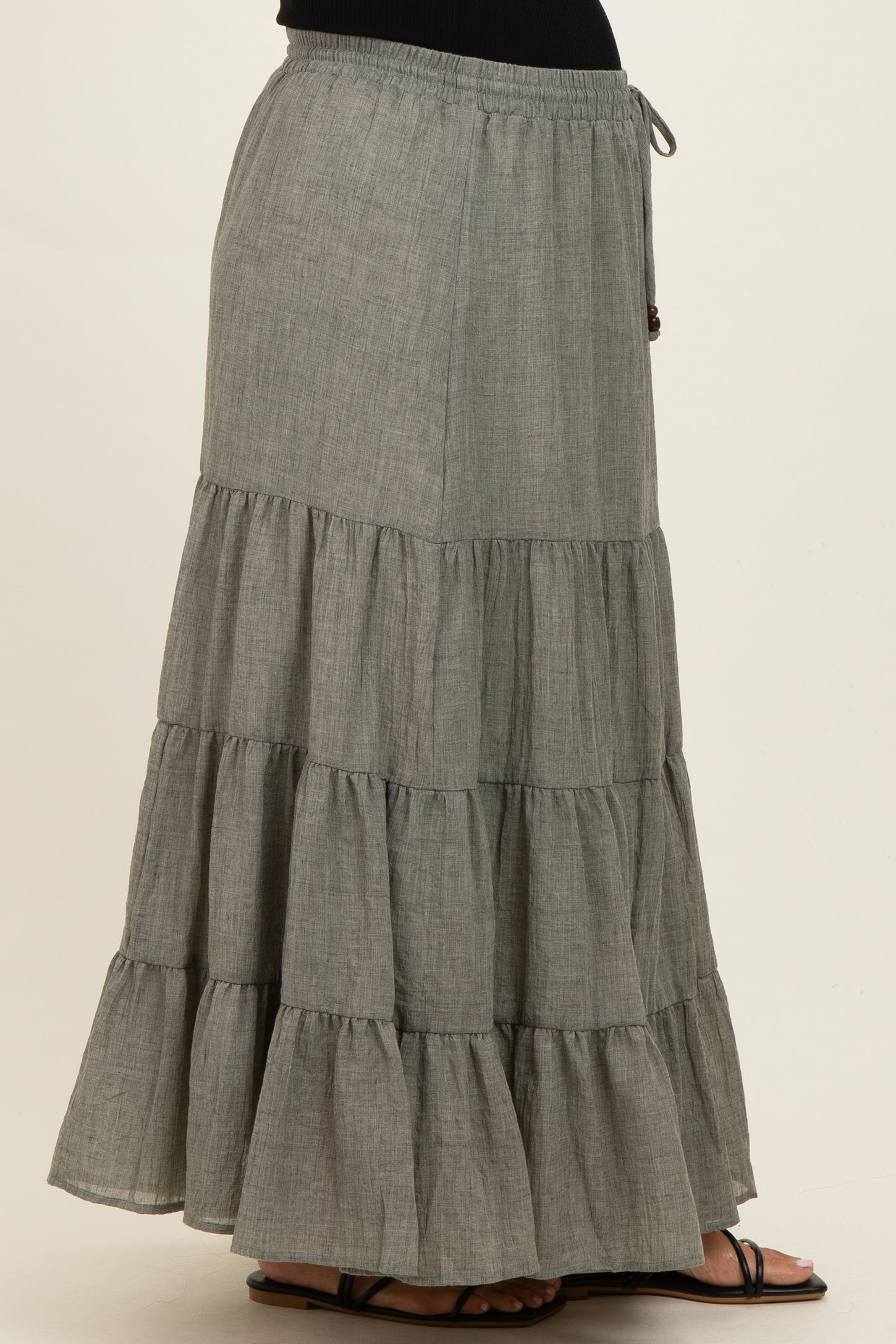 woman wearing a gray tiered maternity maxi skirt with an elastic drawstring waistband