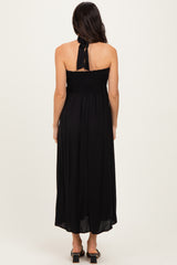 woman wearing a black strapless maxi dress with a smocked bodice and a tie detail at the back