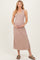 woman wearing a soft beige maternity maxi dress with buttons, gently cradling her baby bump