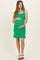 woman wearing a green ribbed maternity dress with ruffle hem and holding her baby bump