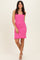 woman wearing a pink knitted mini dress with a ruffled hem and spaghetti straps