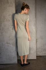 woman wearing a light olive green short sleeve midi dress viewed from the back