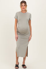 woman wearing a gray short sleeve maternity dress with a side slit and showing her baby bump