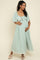 woman wearing a mint green floral maternity maxi dress with a tie front and short sleeves, holding her baby bump