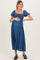 woman wearing a blue maternity dress with puff sleeves and a square neckline, gently holding her baby bump