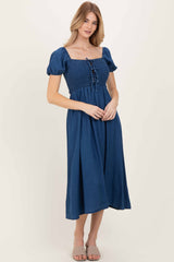 woman wearing a navy blue midi dress with puff sleeves and a smocked bodice