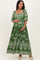 woman wearing a green maternity dress with white floral patterns and short puff sleeves, holding her baby bump