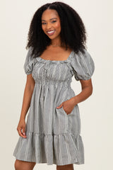 woman wearing a black and white checkered puff sleeve mini dress with a square neckline and pockets