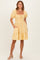 woman wearing a yellow striped puff sleeve dress with a square neckline and pockets