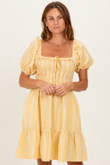 woman wearing a yellow checked puff sleeve dress with a square neckline and ruffled hem