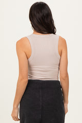woman wearing a beige ribbed tank top, viewed from the back, with a black skirt