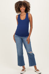 woman wearing a navy blue ribbed maternity tank top and distressed jeans, highlighting her baby bump