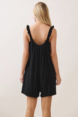 woman wearing a black striped romper with ruffled straps, viewed from the back