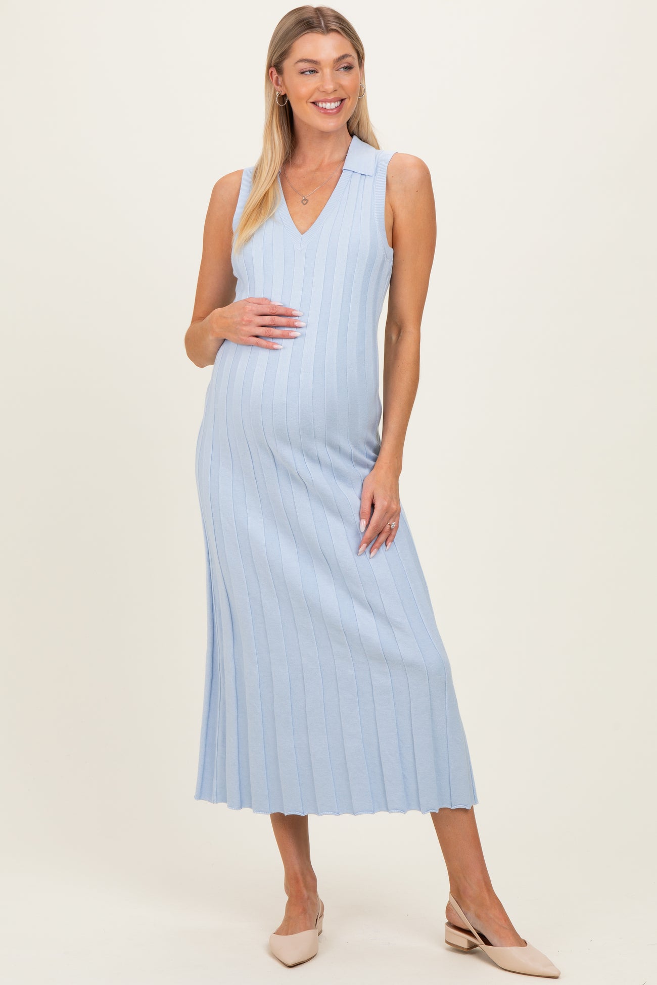 woman wearing a light blue ribbed maternity dress with a v-neck and a visible baby bump