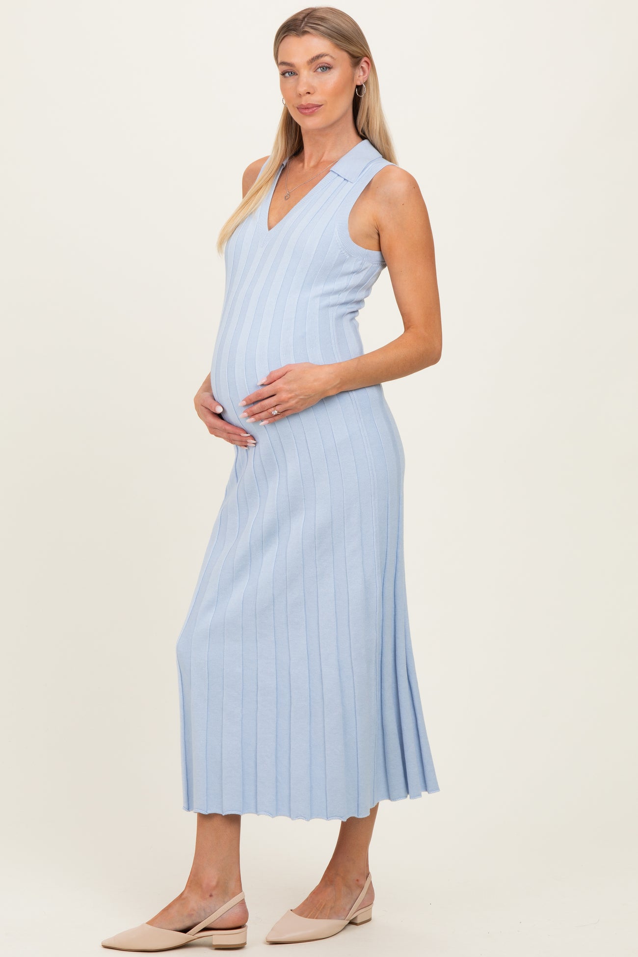 woman wearing a light blue ribbed maternity dress with a v-neck and a visible baby bump