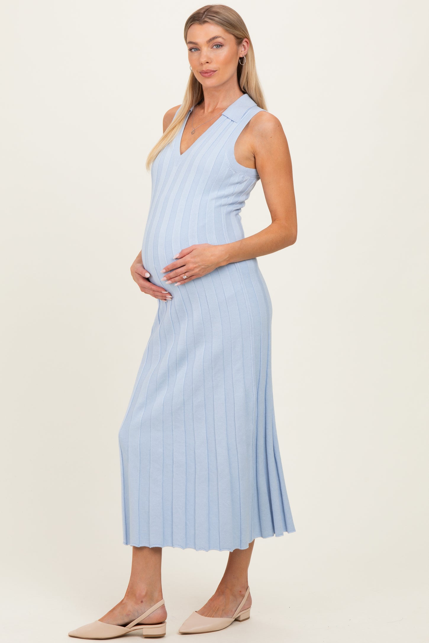 woman wearing a light blue ribbed maternity dress with a v-neck and a visible baby bump