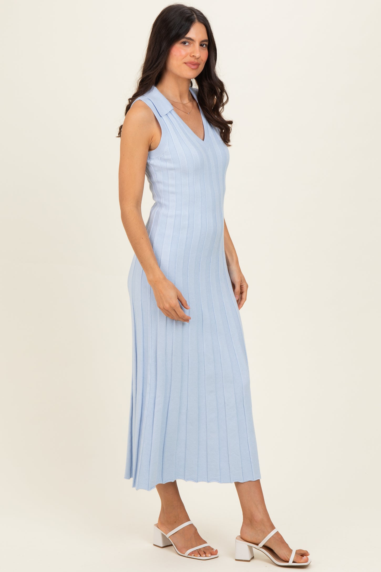 woman wearing a light blue sleeveless ribbed midi dress with a v-neckline and side pleats
