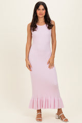 woman wearing a light pink ribbed maxi dress with a ruffle hem and subtle round neckline