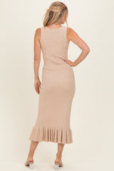 woman wearing a beige ribbed midi dress with a ruffled hem and a back view, styled with a hair accessory
