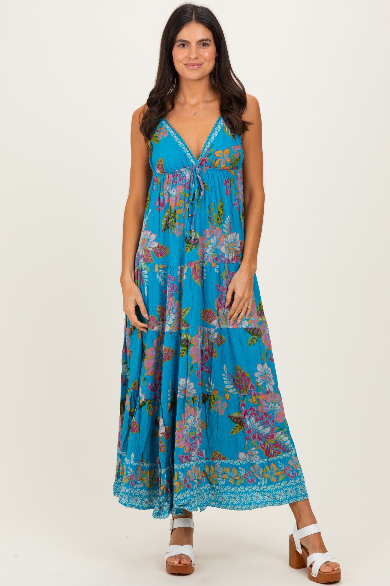 woman wearing a blue floral maxi dress with a drawstring detail and a tiered hemline