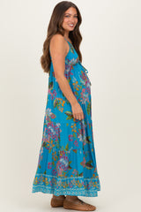 woman wearing a blue floral maternity maxi dress with a tie detail and visible baby bump