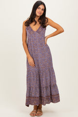woman wearing a purple patterned maxi dress with a v-neckline and tiered skirt