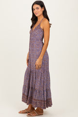 woman wearing a purple patterned maxi dress with a tiered skirt and spaghetti straps