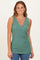 woman wearing a green sleeveless crossover top with a textured finish and a fitted silhouette