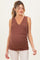 woman wearing a rust-colored sleeveless maternity top with a wrap design and visible baby bump