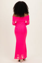 woman wearing a bright pink off-the-shoulder maxi dress with a fitted silhouette and long sleeves