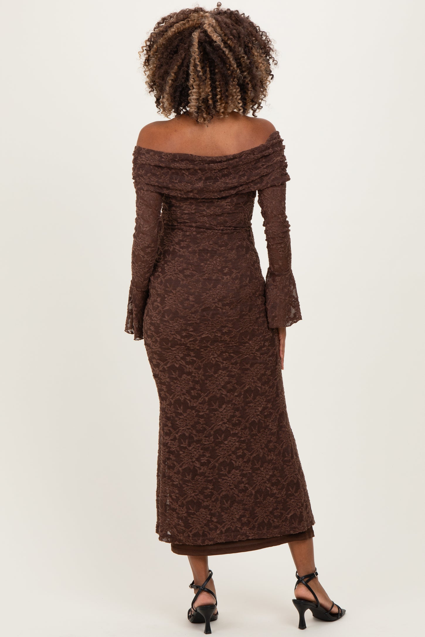 woman wearing a brown off-shoulder lace maternity dress with bell sleeves and a fitted silhouette