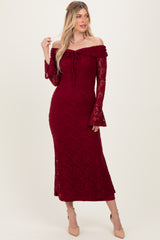 woman wearing a burgundy off-the-shoulder lace dress with bell sleeves and a fitted silhouette