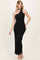 woman wearing a black sleeveless maxi dress with a halter neckline and a side slit, standing elegantly