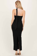 woman wearing a black halter neck maxi dress with a back tie detail and side slit