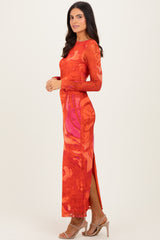 woman wearing a long sleeve red floral maxi dress with side slits and a fitted silhouette