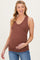 woman wearing a rust ribbed maternity tank top and holding her baby bump