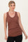 woman wearing a rust ribbed tank top with a v-neckline and fitted silhouette, paired with black jeans