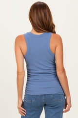 woman wearing a blue ribbed tank top with gathered side detail and styled with high-waisted jeans