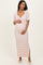 woman wearing a pink and white striped maternity maxi dress with a knotted front and side slit, holding her baby bump