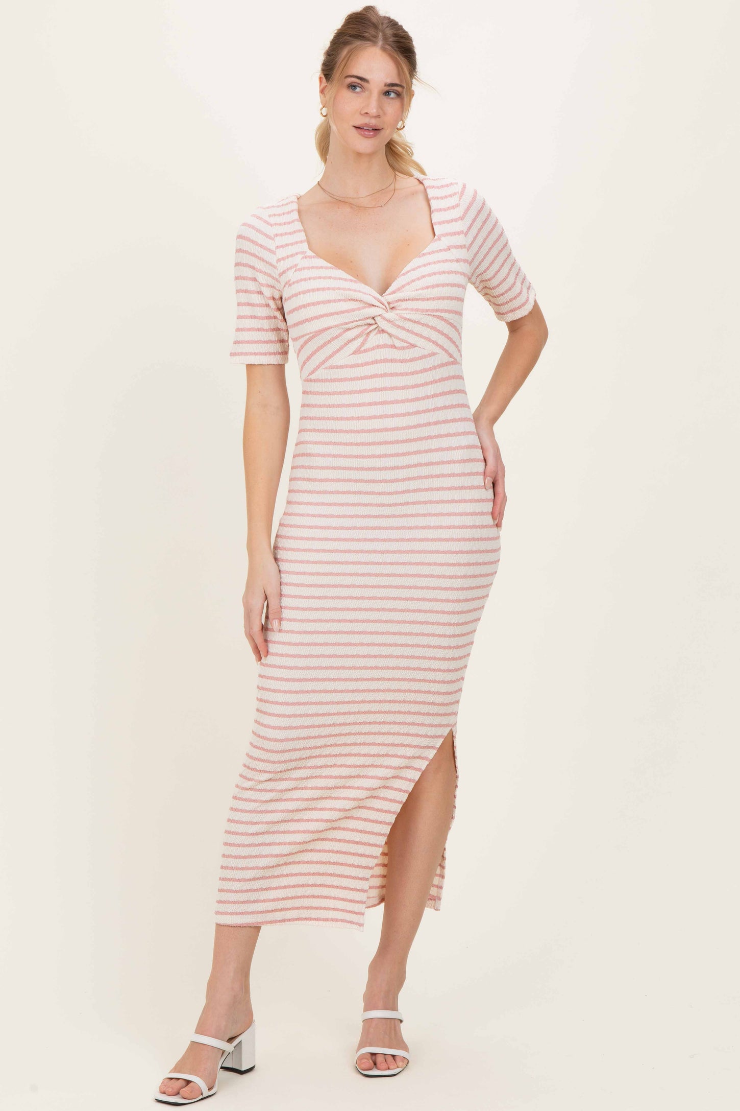 woman wearing a striped midi dress with short sleeves and a side slit, styled with open-toe heels