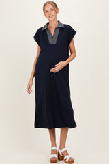 woman wearing a navy blue maternity dress with a striped collar and a visible baby bump