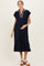 woman wearing a navy blue maternity dress with a striped collar and a visible baby bump