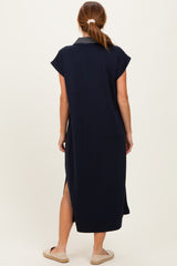 woman wearing a navy blue short sleeve maxi dress with a striped collar and side slits