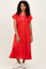 woman wearing a vibrant red short sleeve maxi dress with a V-neck and side slits, standing in white sneakers