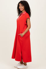 woman wearing a red maxi dress with short sleeves and a striped collar, posing with hands in pockets
