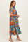 woman wearing a colorful tropical print midi dress with short sleeves and ruffle hem